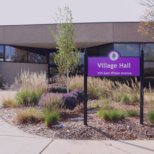 Exterior of Lombard Village Hall with a purple sign that reads ‘Village Hall, 255 East Wilson Avenue