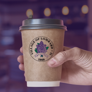 Hand holding a coffee cup with the Village of Lombard seal on a purple background.