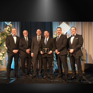 Group of award recipients posing with a plaque at the ACEC awards event