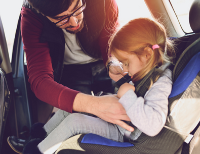 Parent buckling child in safety car seat