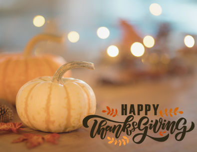 small white and small orange pumpkins on wood table with happy thanksgiving text